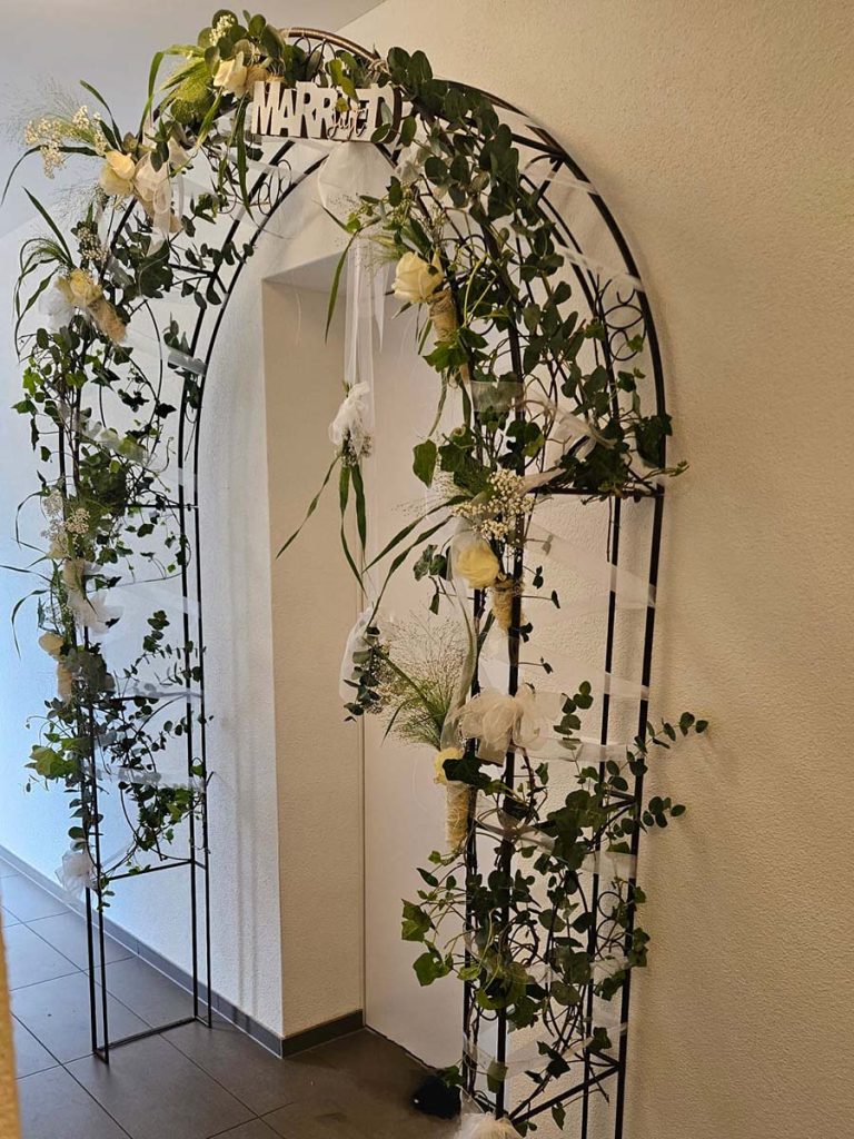Hochzeitsbogen mit Blumen vor dem Standesamt